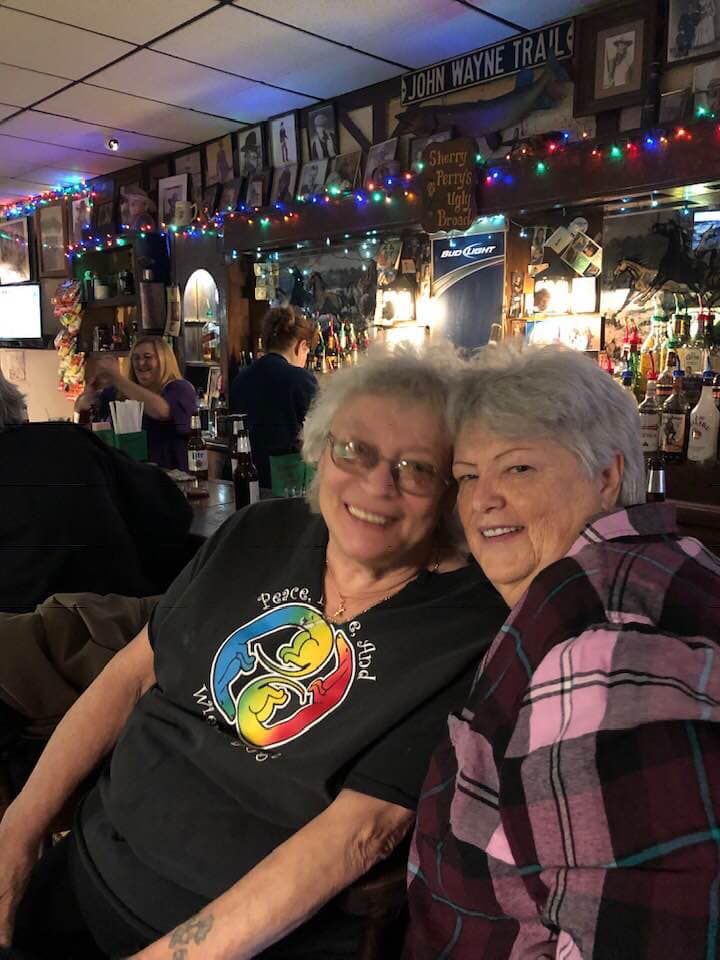 Two people sitting at the bar, smiling for the photo.