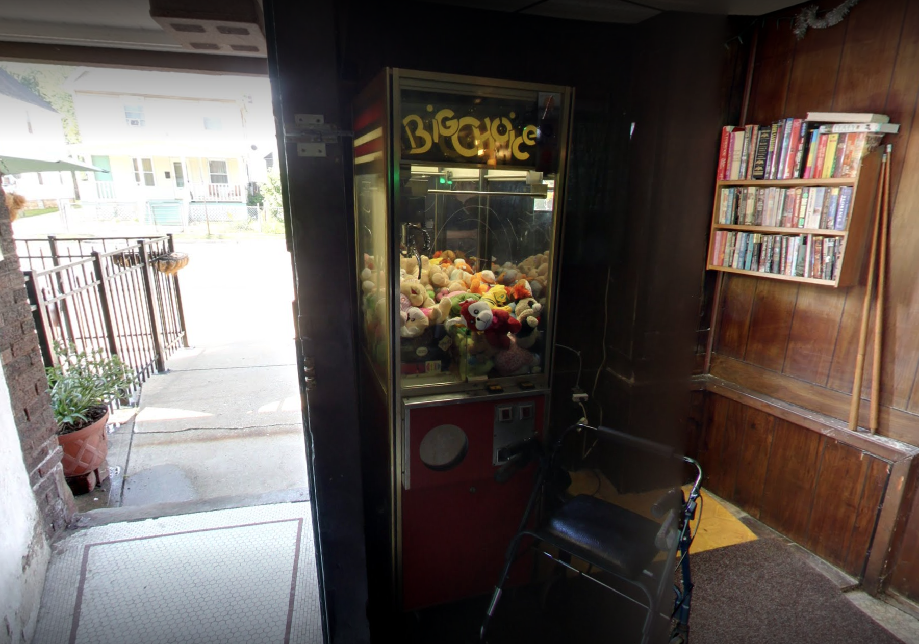 Claw machine next to an open door to the outside.