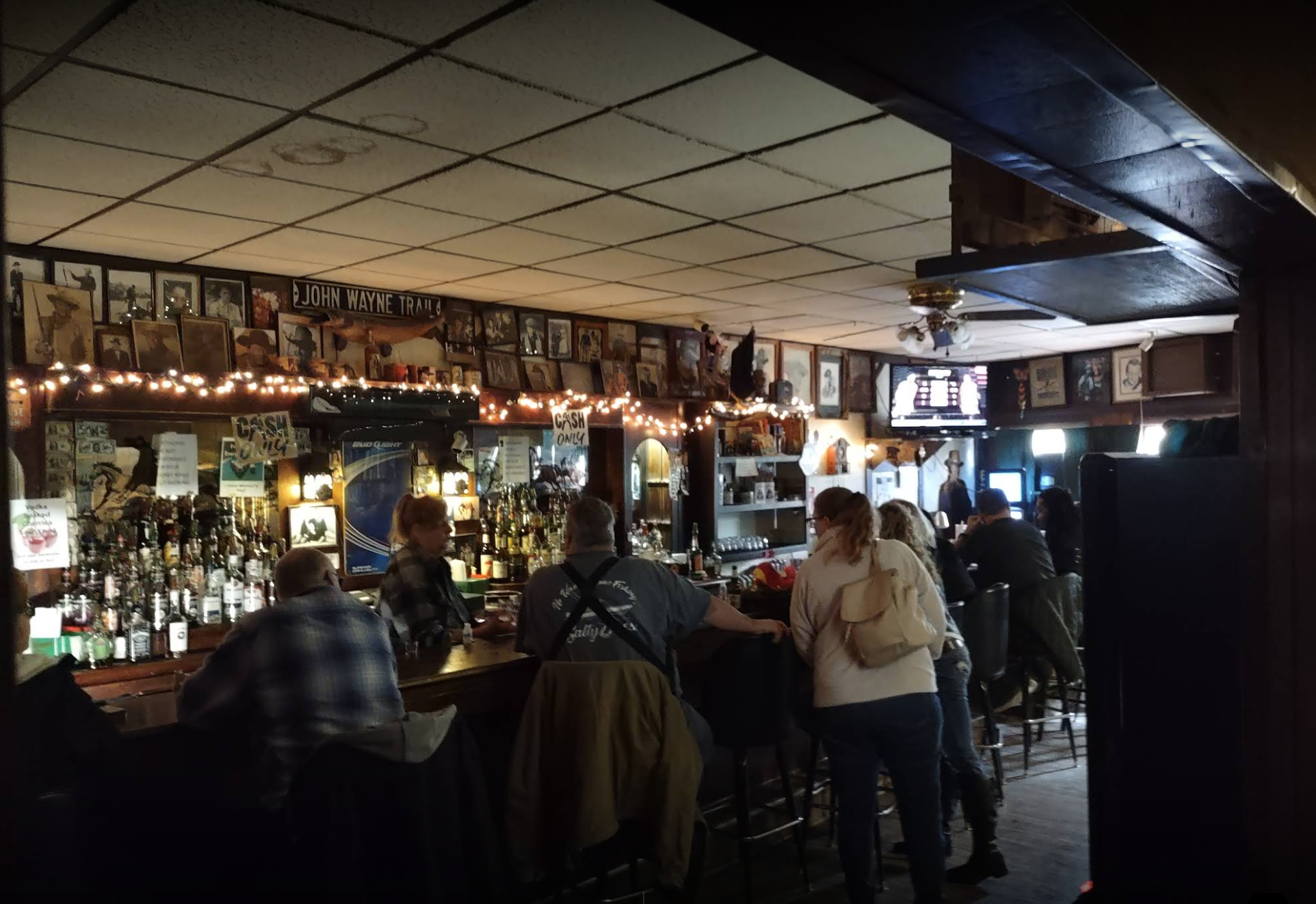 Interior shot of The Ugly Broad, with every seat at the bar filled.