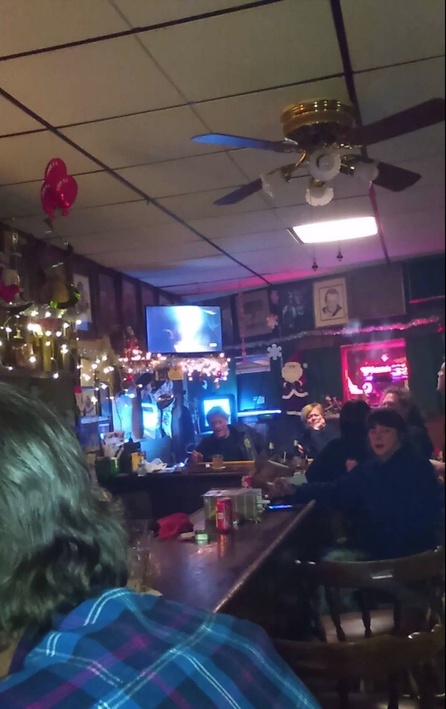 People sitting around the bar with Christmas decorations around.