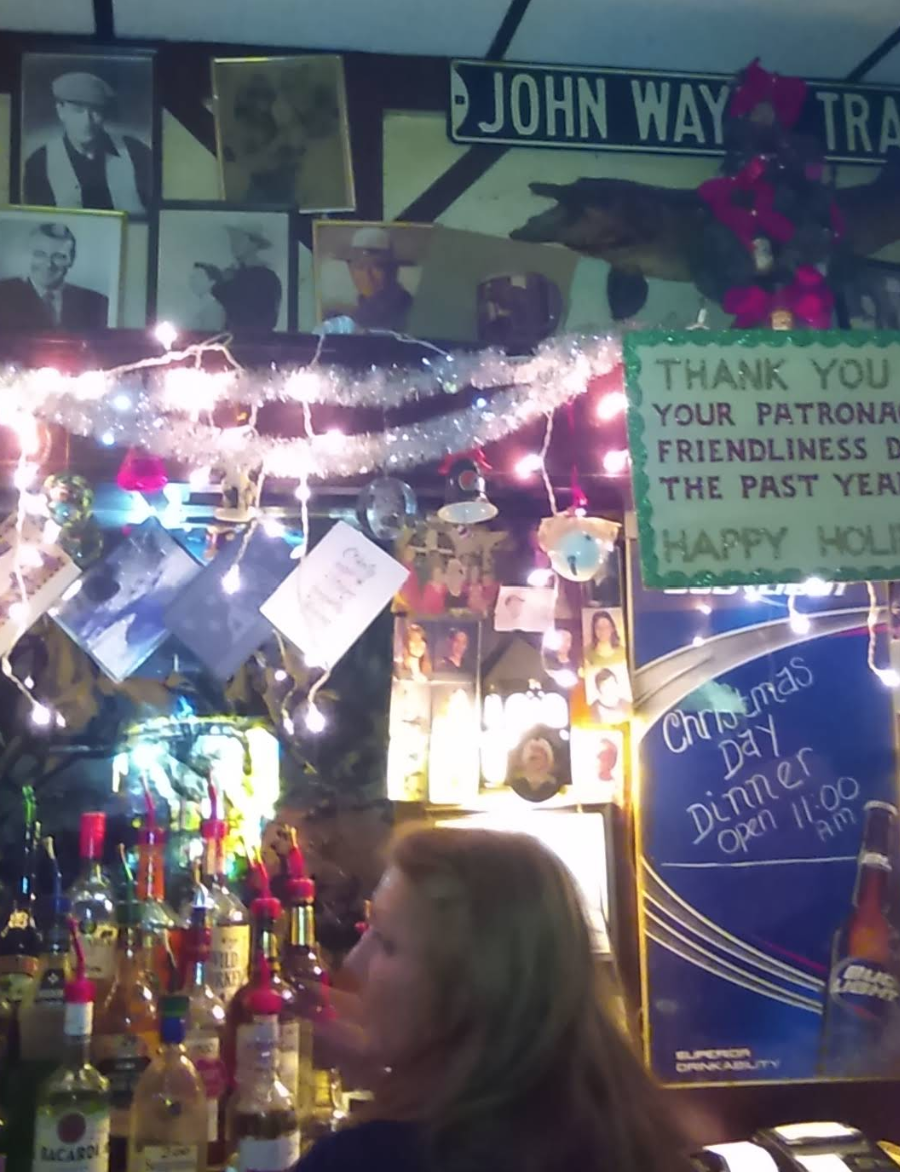 Close-up of the decorations behind the bar, a combination of John Wayne photos and Christmas decorations.