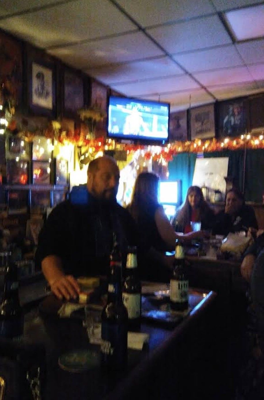 People at the bar with bartenders behind the bar.