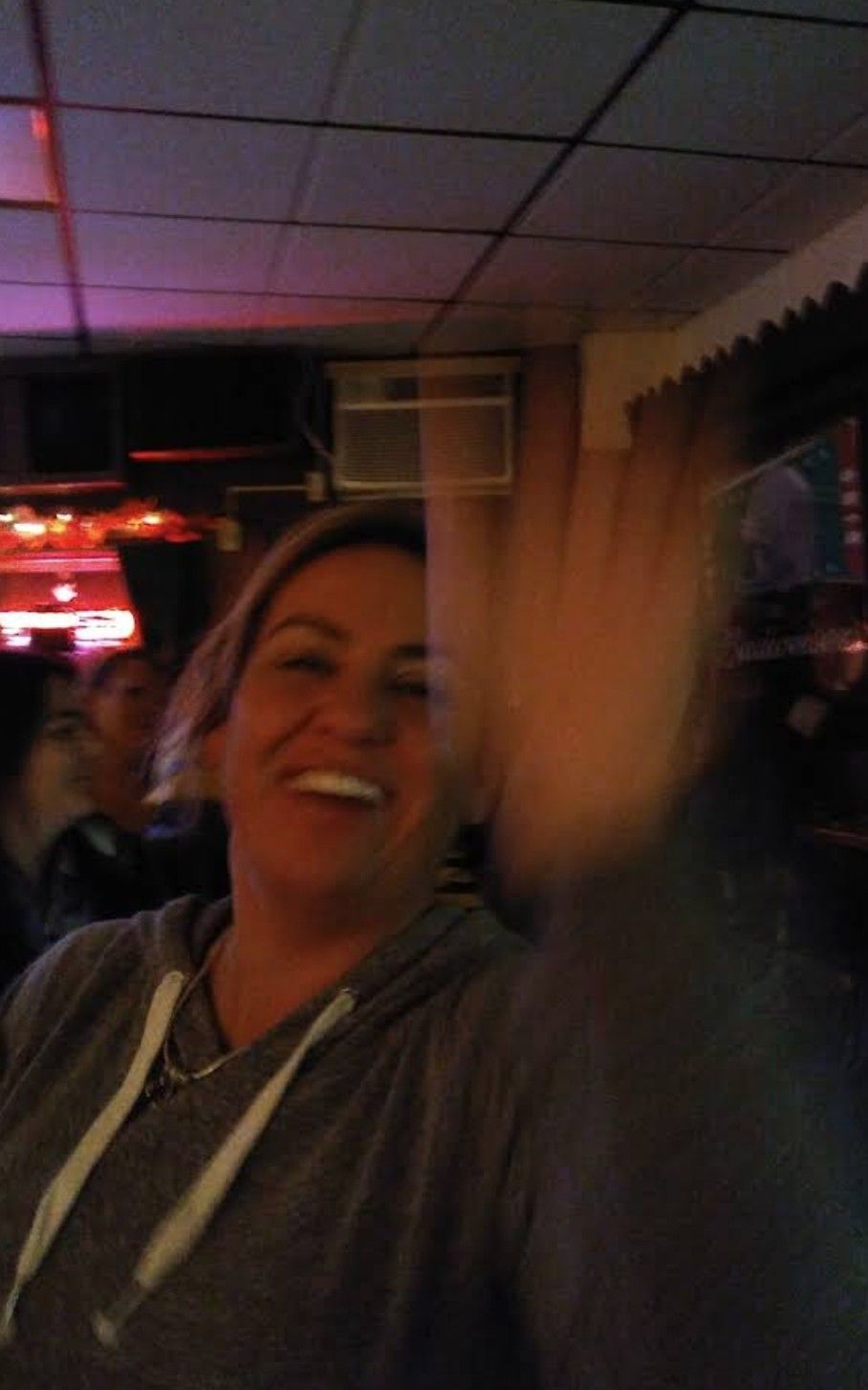Woman waving at the camera.