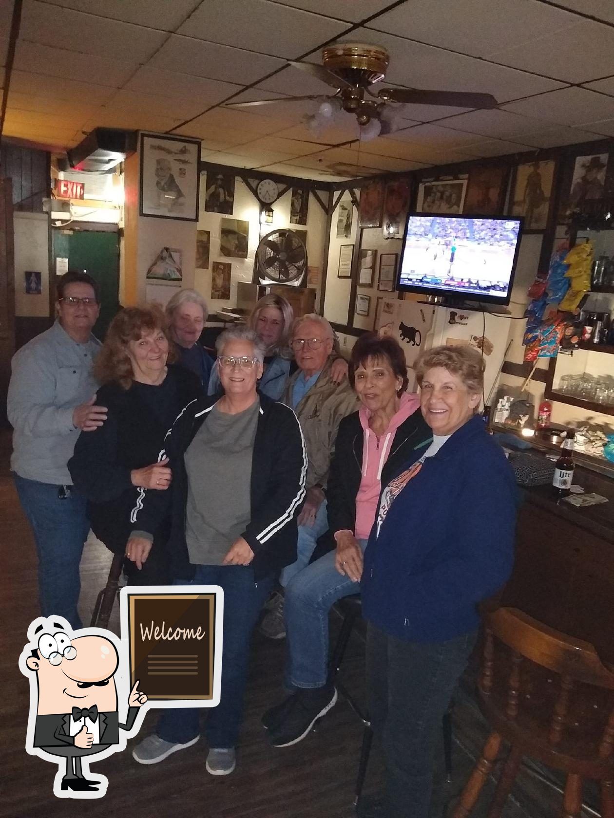 Group of people standing in front of the bar at The Ugly Broad.