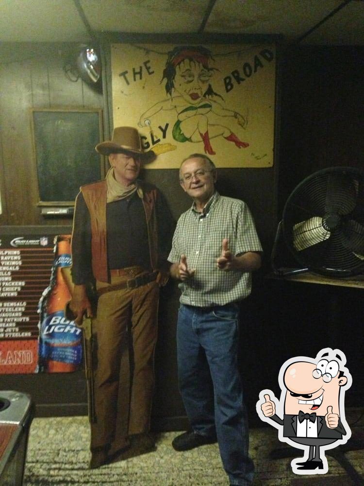 Man standing with cardboard cut-out of John Wayne.