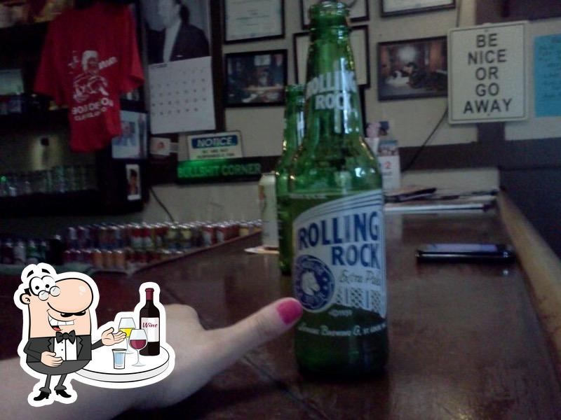 Hand with pink nail polish in front of a bottle of Rolling Rock.
