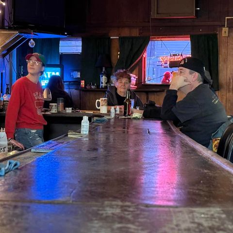 Sherry and another person sitting at the bar with a bartender behind the bar.
