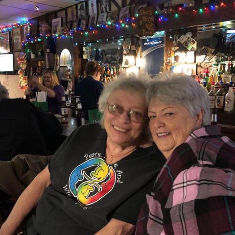 Two people sitting at the bar, smiling for the photo.