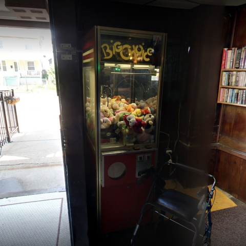 Claw machine next to an open door to the outside.