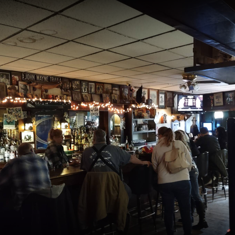 Interior shot of The Ugly Broad, with every seat at the bar filled.
