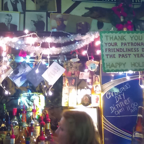 Close-up of the decorations behind the bar, a combination of John Wayne photos and Christmas decorations.