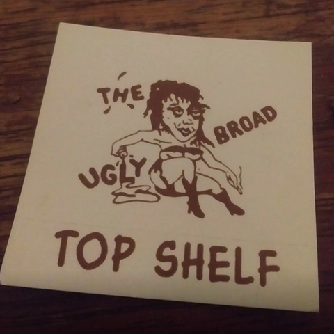 Card with The Ugly Broad logo that says 'Top Shelf'.