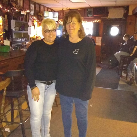 Two women standing inside The Ugly Broad.