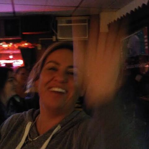 Woman waving at the camera.