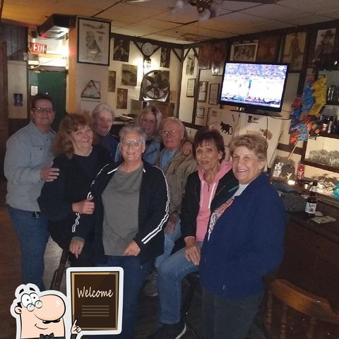 Group of people standing in front of the bar at The Ugly Broad.