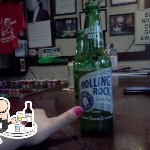 Hand with pink nail polish in front of a bottle of Rolling Rock.